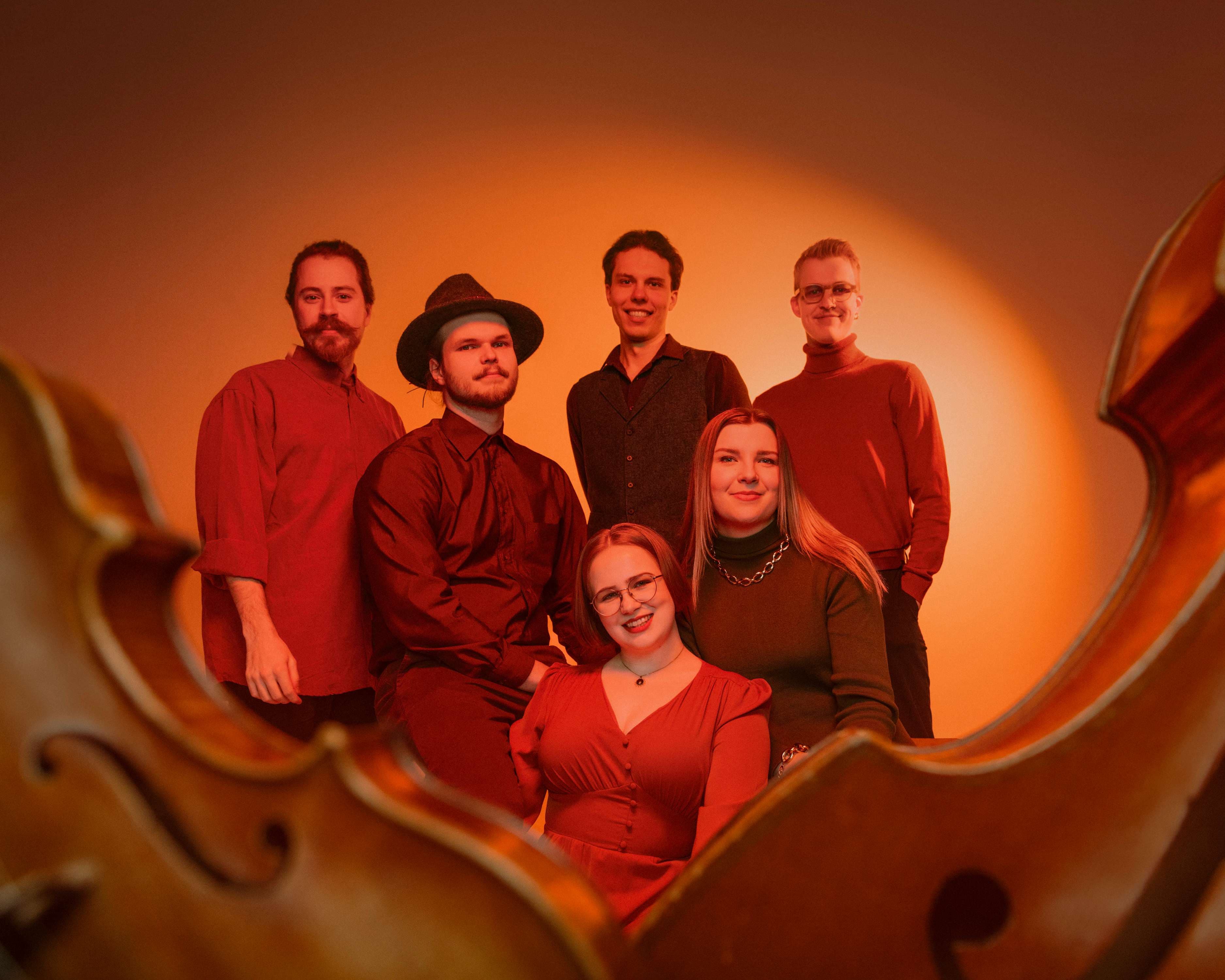 a group of people posing in front of a cello
